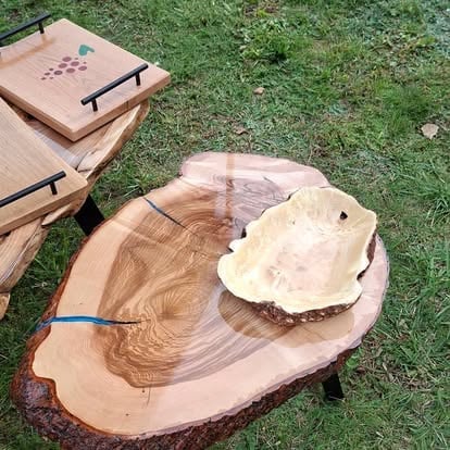 Dębowe plastry i deski z naturalną krawędzią ułożone na trawie podczas pracy w pracowni